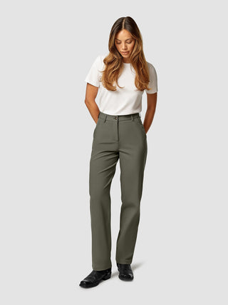 En kvinna klädd i en vit t-shirt och Essential Pants Straight i färgen Dark Olive.