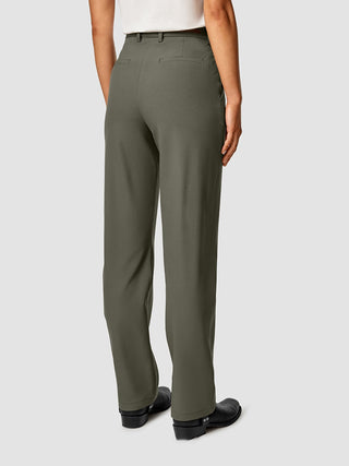 En person sedd bakifrån, klädd i Essential Pants Straight i färgen Dark Olive och svarta stövlar.