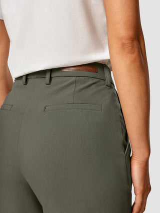 Närbild på Essential Pants Straight i mörk olivgrön, där man ser en logotyp i brunt läder på det khakifärgade midjebandet.