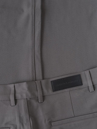 Essential Pants Slim Grey med en svart etikett med texten SHAPING NEW TOMORROW.