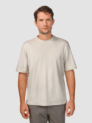En man klädd i en Heavy Box Fit-T-shirt i färgen Off White.