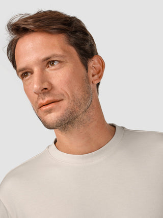 En man med lätt skäggstubb som bär en T-shirt i modell ”Heavy Box Fit” från Off White.