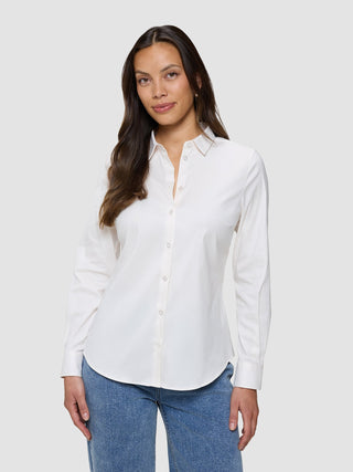 En kvinna klädd i en vit Oxford-skjorta i modellen White Orchid Slim för damer och blå jeans.