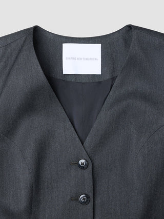 Närbild på en Skye Long Vest för dam i färgställningen ”Charcoal Melange” med en märkesetikett från Shaping New Tomorrow på insidan av halsringningen.