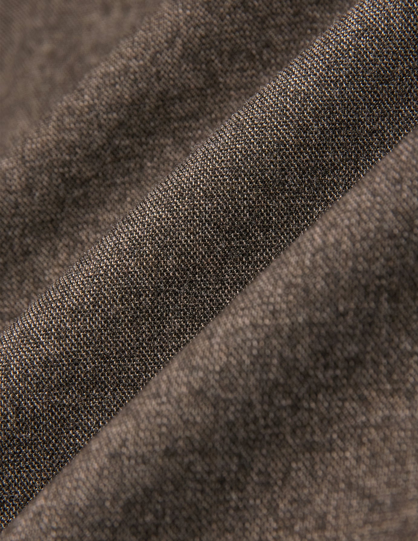 Närbild på Atelier Overshirt Dark Beige, som visar ett tvillvävt tyg med synliga veck i vävnaden.