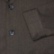 Närbild på Atelier Overshirt Dark Brown, med en mörkbrun, strukturerad väv i bruten twill och tre mörka knappar.