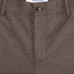 Närbild på midjebandet, knappen och mittsömmen på byxorna Atelier Pants Relaxed Dark Beige i bruten twill.