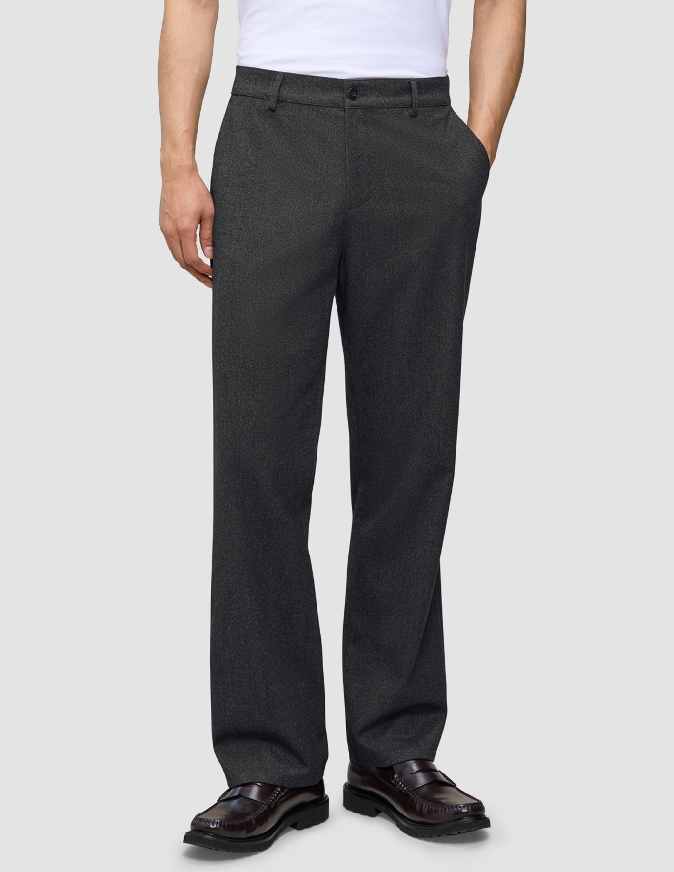 Mörkgråa byxor i avslappnad passform, modell Atelier Pants Relaxed Dark Grey, i bruten twill med knäppning och mörka läderloafers.