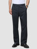 En person som bär marinblåa Atelier Pants Relaxed Dark Navy i bruten twill med avslappnad passform och svarta kostymskor.