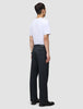 En person sedd bakifrån, klädd i en vit t-shirt och byxor av modellen Atelier Pants Relaxed Dark Navy.
