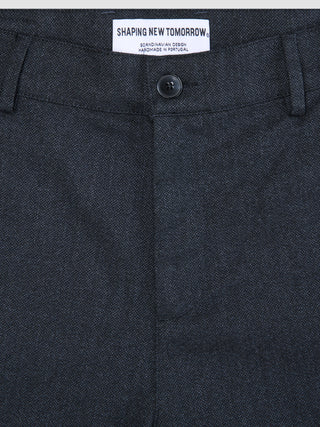 Närbild på byxorna Atelier Pants Relaxed Dark Navy i bruten twill med knäppning och invändig märkesetikett.