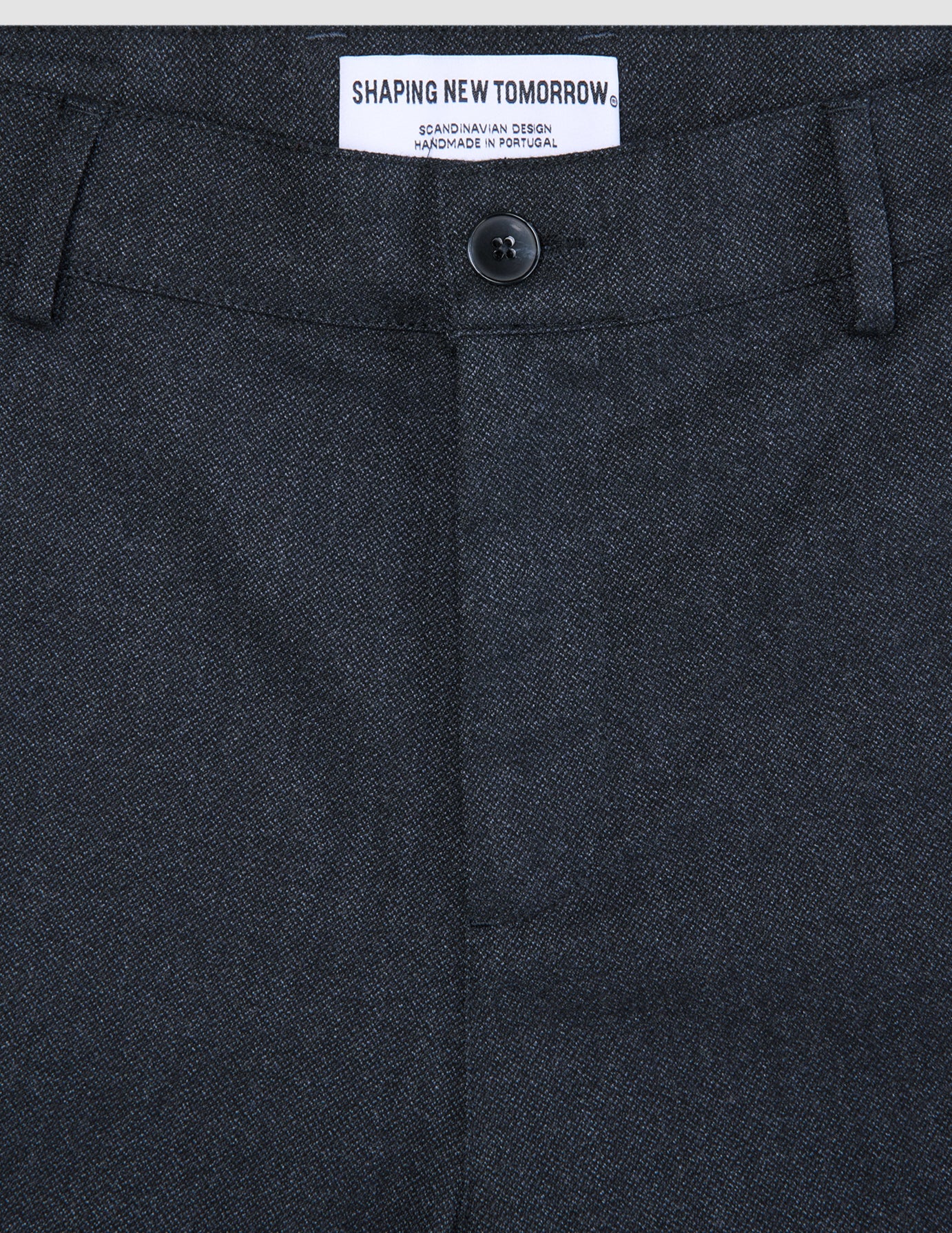 Närbild på byxorna Atelier Pants Relaxed Dark Navy i bruten twill med knäppning och invändig märkesetikett.