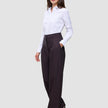 En kvinna bär en vit skjorta med knappar och dambyxorna Avira Pants Wide Burgundy Berry i en festlig passform.