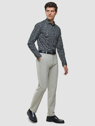 En man bär en Classic Shirt Grey Floral Regular, ljusa byxor och svarta loafers.