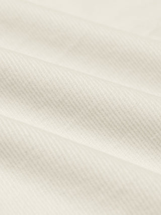 Närbild på en corduroy-skjorta i benvit färg med diagonala räfflor.