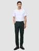 En man i en vit t-shirt och Ease Pants Regular Northern Pine står vänd framåt.