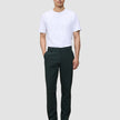 En man i en vit t-shirt och Ease Pants Regular Northern Pine står vänd framåt.