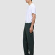 En man, sedd i profil, bär en vit t-shirt och Ease Pants Relaxed Fit Northern Pine, med en skandinavisk design i avslappnad passform.