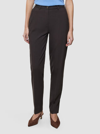 En person som bär högmidjade Women Ease Pants Tapered i färgen Mocha Melange och bruna högklackade skor med spetsig tå.