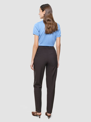 En kvinna sedd bakifrån, klädd i en ljusblå kortärmad topp och ett par Women Ease Pants Tapered Mocha Melange samt högklackade skor.