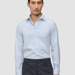 En man i en ljusblå och vitrandig Elevated Shirt Slim Classic Blue Striped tillsammans med mörkgrå byxor.