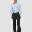 En man klädd i en Elevated-skjorta, modell Slim Classic Blue Striped, tillsammans med mörka byxor och svarta loafers.