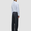 En man sedd bakifrån, klädd i en blå randig Elevated Shirt Slim Classic som är instoppad i kolgrå byxor och svarta loafers.