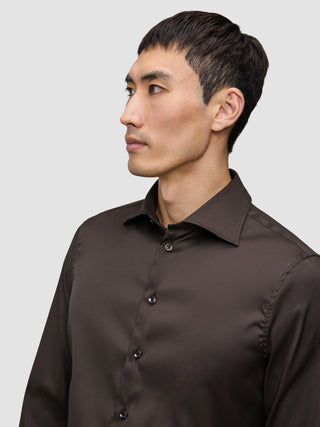 En man klädd i en mörkbrun Elevated Shirt Slim med skandinavisk design.