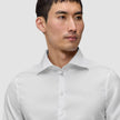En man klädd i en Elevated Shirt White Slim, en vit skjorta med smal passform och utbredd krage i minimalistisk design.