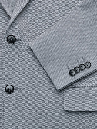 Närbild på Essential Blazer Regular Ash Twill, med mörka knappar på framsidan och ärmarna.