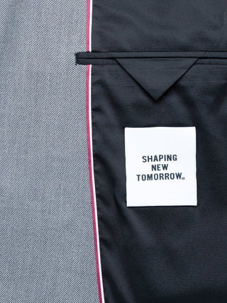 Insidan av en Essential Blazer Regular Ash Twill med en vit Shaping New Tomorrow-märkesetikett och tekniskt tyg.