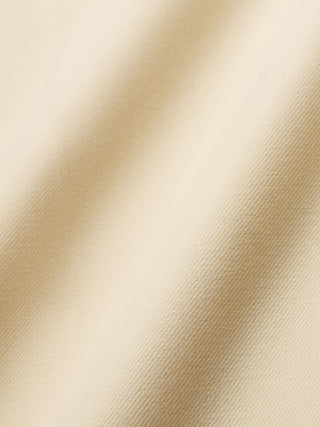 Närbild på Women Essential Pants Tapered i färgen Misty Yellow – beige tyg med diagonalt vävt mönster och 360°-stretch.