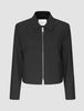 Essential Short Zip Jacket Black: en minimalistisk, kort svart jacka med en helsilverfärgad dragkedja framtill.