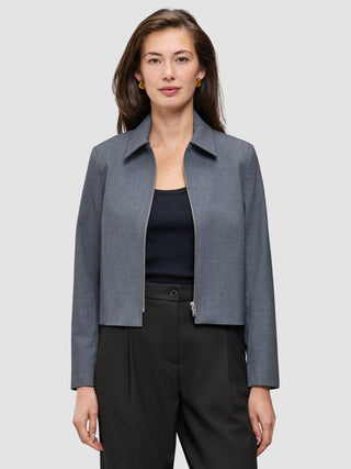 En kvinna som bär en mörkgrå Essential Short Zip Jacket i mörkgrå melange över en svart topp.
