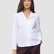 En kvinna klädd i en Madison Shirt White, en vit skjorta med knappar, skärad krage och långa ärmar.