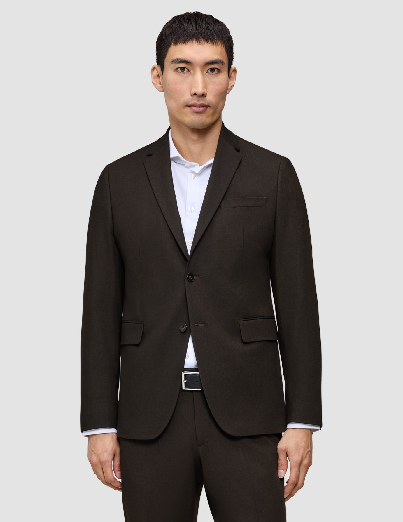 En man som bär en Motion Blazer Regular Cognac, en tvåknappsblazer, över en vit skjorta med krage.