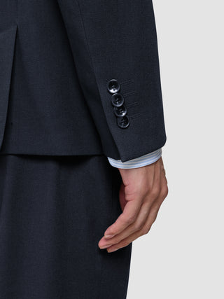Närbild på en ärm från en Motion Blazer Regular i färgen Midnight Blue, där fyra manschettknappar syns och en ljus skjorta.