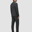 En man sedd bakifrån, klädd i en Motion Blazer Regular Pepper Grey-jacka och matchande byxor samt mörka loafers.