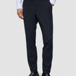 Slim-fit Motion Suit-byxor i färgen Slim Midnight Blue med 360°-stretch, kombinerade med en vit skjorta och mörka loafers.