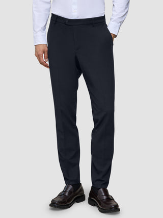 Slim-fit Motion Suit-byxor i färgen Slim Midnight Blue med 360°-stretch, kombinerade med en vit skjorta och mörka loafers.