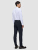 En person sedd bakifrån, klädd i en vit skjorta, Motion Suit-byxor i modell Slim i färgen Midnight Blue och mörka loafers.