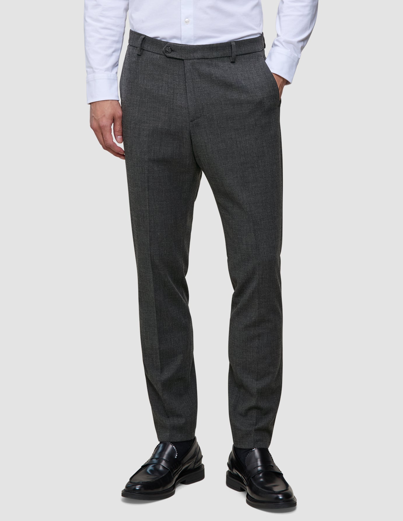 Slim-fit Motion Suit-byxor i färgen Slim Pepper Grey med 360°-stretch, kombinerade med en vit skjorta och svarta loafers.