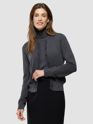 En kvinna klädd i en ”Women Quinn Crewneck Cardigan Cool Brown” över en matchande polotröja och en svart kjol.