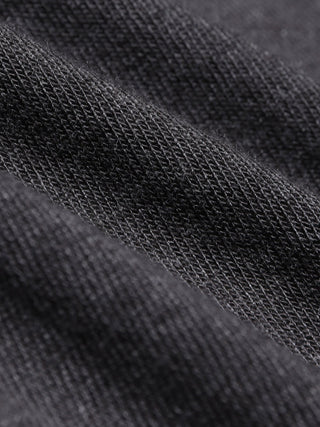 Närbild på svart stickat tyg i dammodellen Quinn Crewneck Cardigan i färgen Cool Brown.