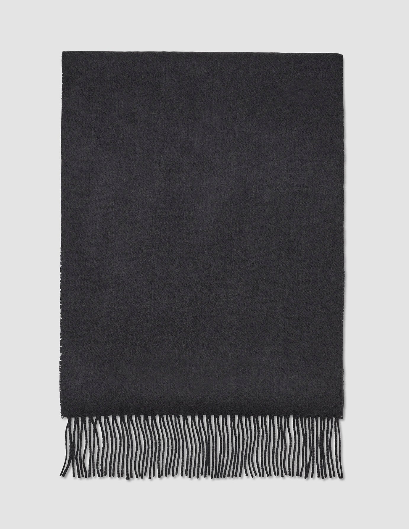 Halsduk i kolgrått, tillverkad av ull med fransar i ena änden, i klassisk skandinavisk design.