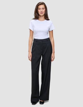 En kvinna klädd i en vit t-shirt och svarta, vidbyxor av modellen Serene Pants Wide Black.