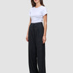 Kvinna klädd i en vit t-shirt och svarta Serene Pants Wide med hög midja.