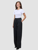 En kvinna klädd i en vit t-shirt och svarta Serene Pants Wide Black med hög midja.