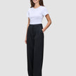 En kvinna klädd i en vit t-shirt och svarta Serene Pants Wide Black med hög midja.