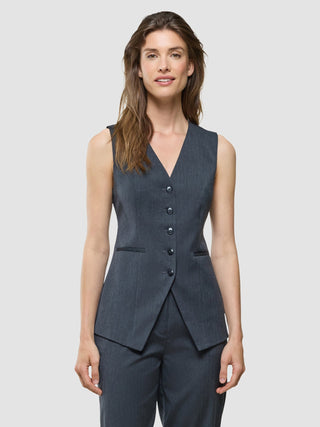En kvinna som bär en lång damväst av modellen ”Skye” i färgen ”Charcoal Melange”.